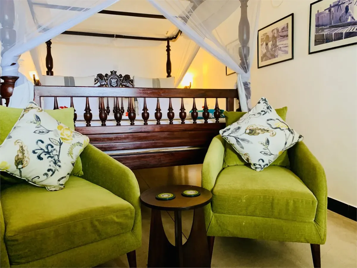 Heritage seating beside a four-poster bed at Suite Lanka